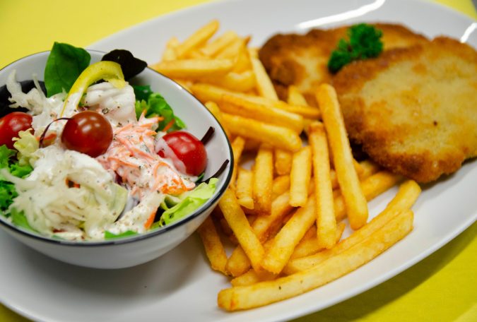 Panierte Schnitzel mit Pommes frites und gemischtem Salat.